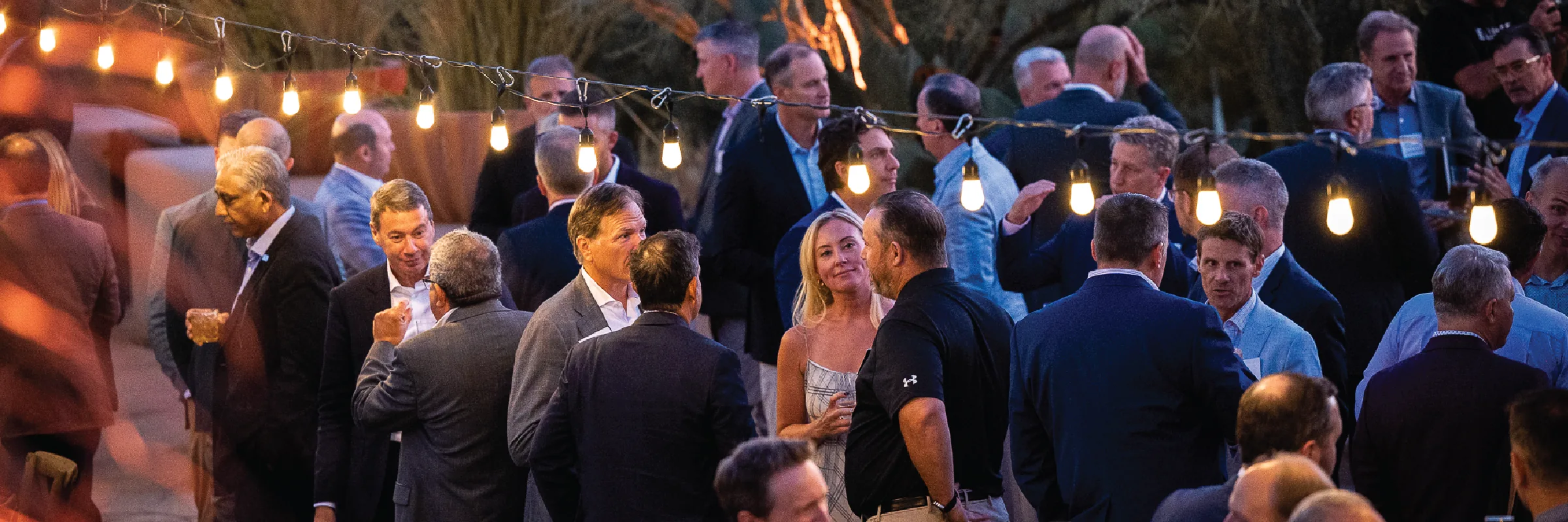 Evening networking under string lights at an AEC Advisors summit