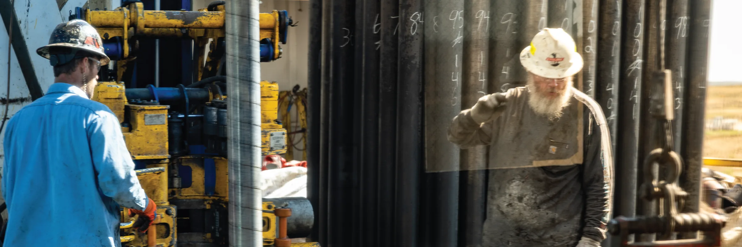 Crew members working at the rig beside a chalk tally board