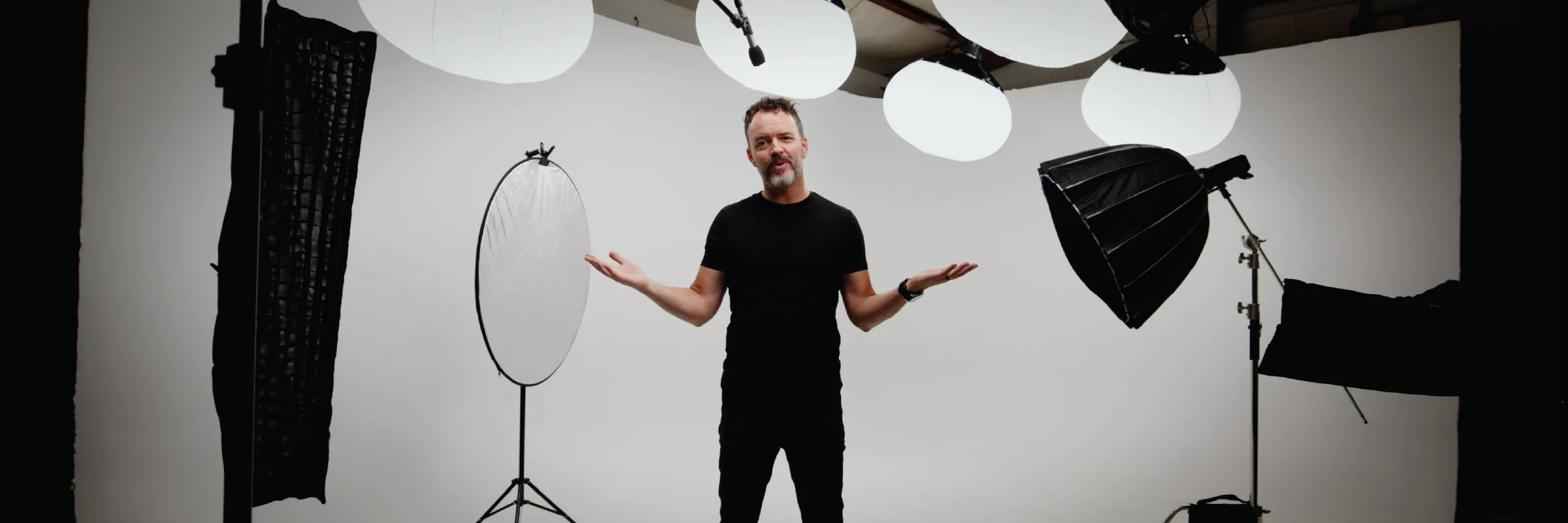 Josh Miles on the 20-by-14-foot cyc wall at Fox Photo Studios, surrounded by lanterns, softboxes, and reflectors