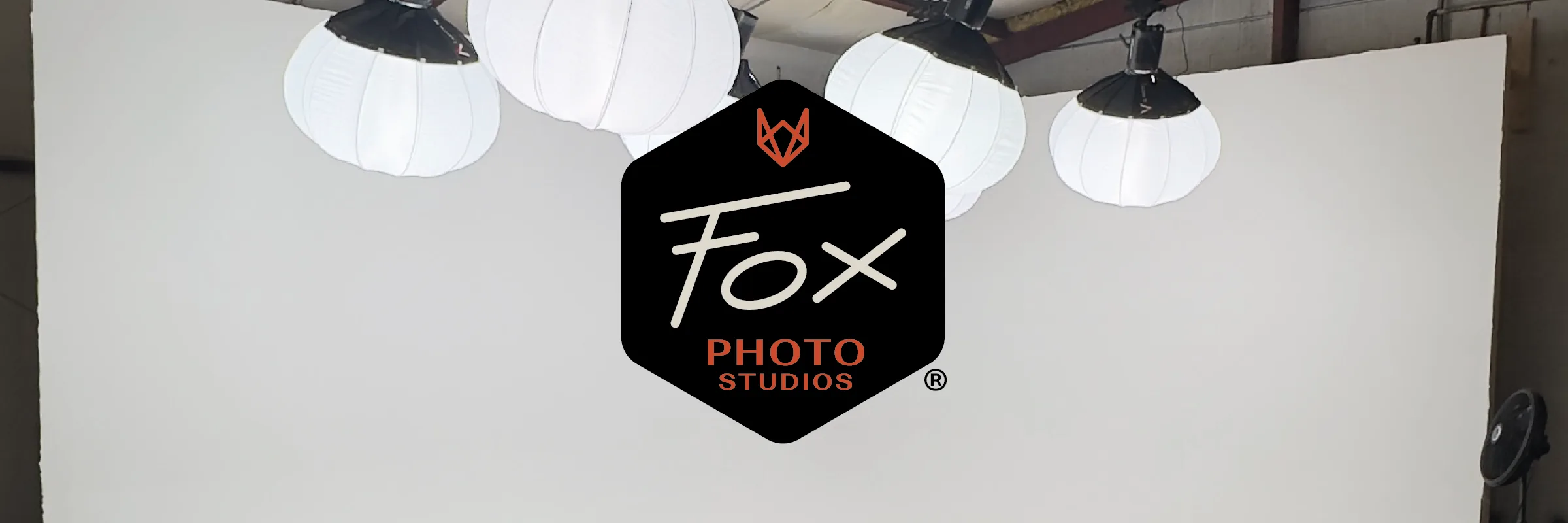 The Fox Photo Studios hexagonal badge over the studio's cyc wall and lantern lights