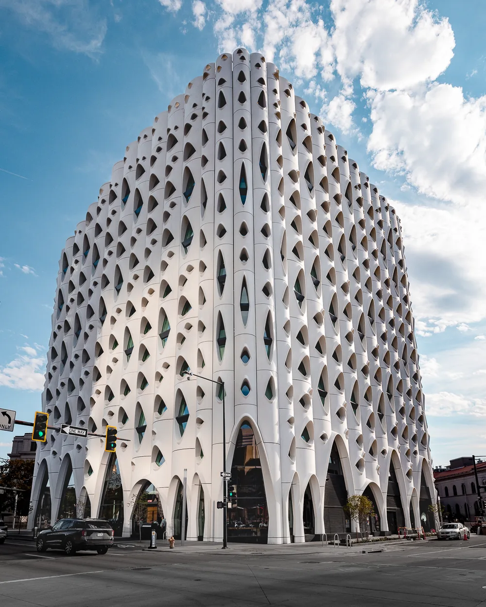 Sculptural white perforated building facade against blue sky