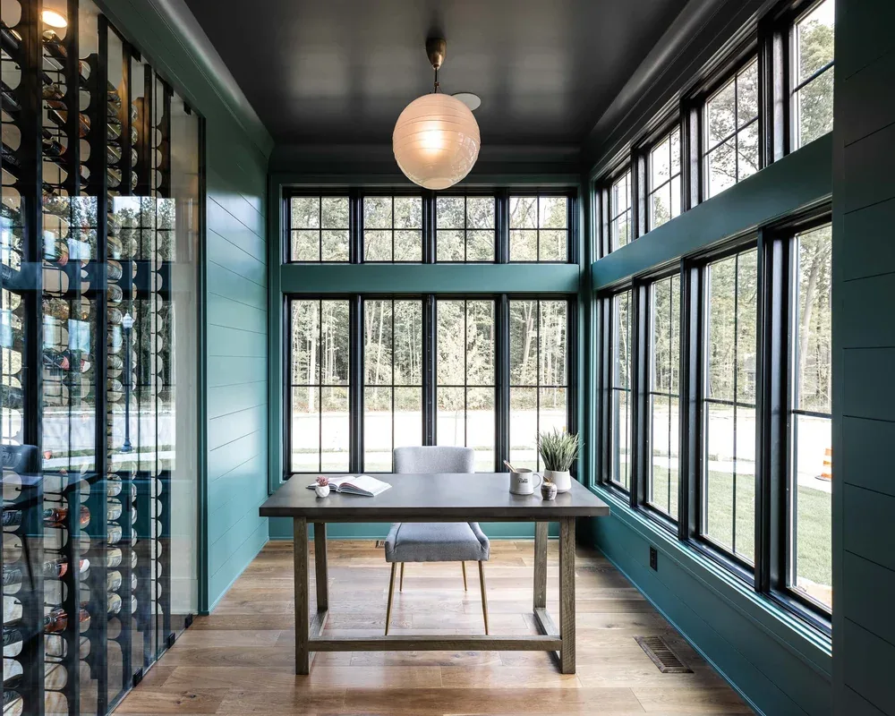 Home study interior with dark millwork and wall of windows