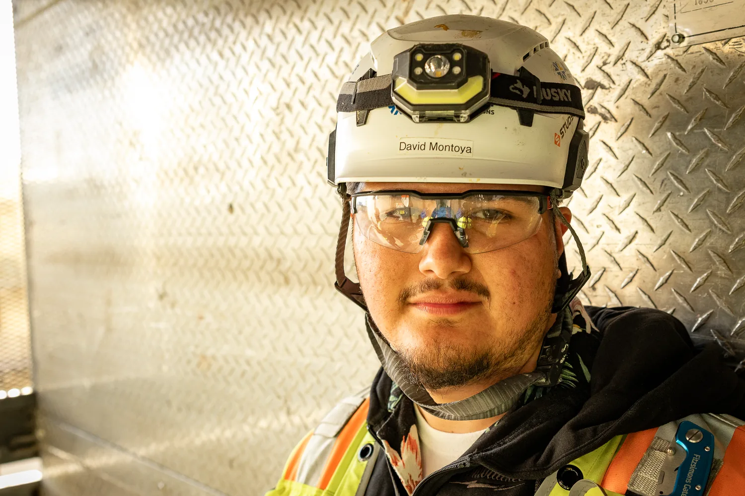 Construction worker portrait with headlamp and safety glasses
