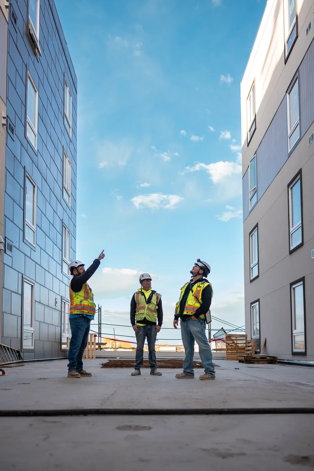 Crew reviewing progress outside a multifamily building under construction