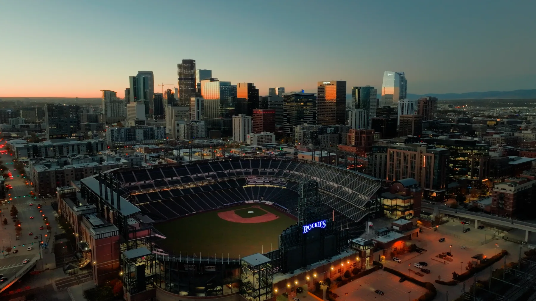 Coors Field and the Denver skyline at dusk, aerial view