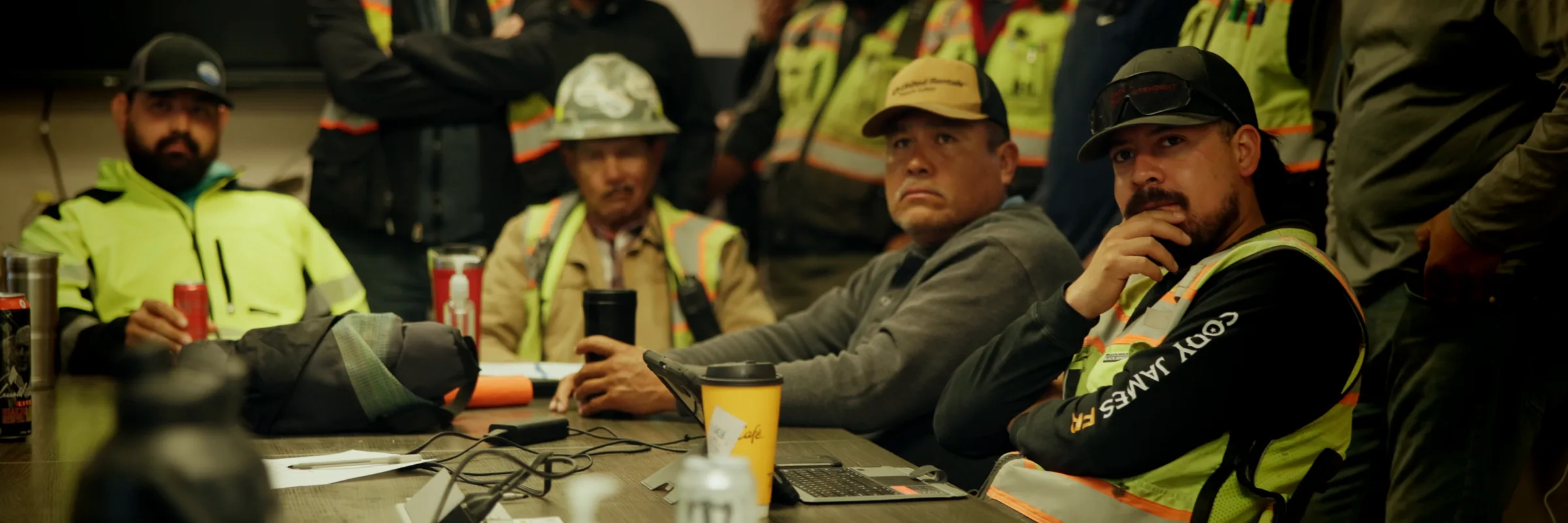 JHL field crew gathered around a table for a morning safety meeting